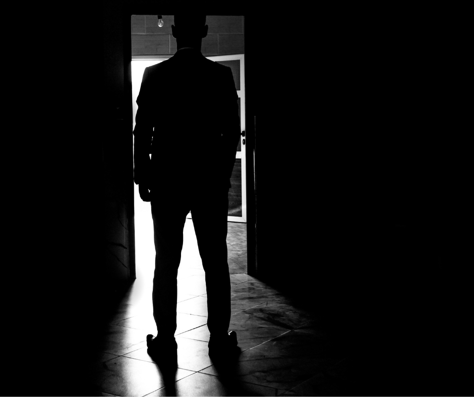 person backlit walking through a door